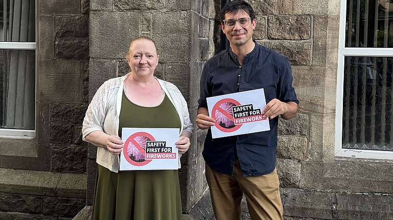 Councillors Helen Bishop and Sam Al-Hamdani holding up signs saying Safety First for Fireworks