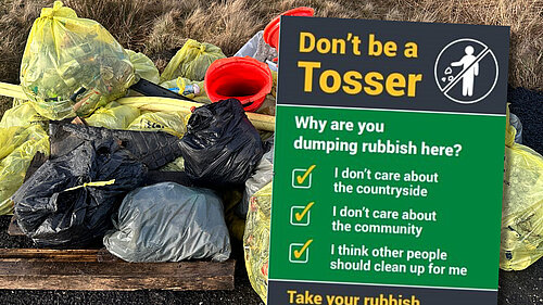 "Don't be a Tosser" poster in front of a picture of litter collected by local volunteers  