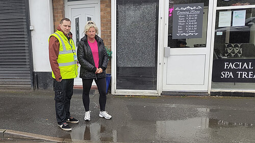 Councillor Louie Hamblett and Debbie Morris standing beside the flooding